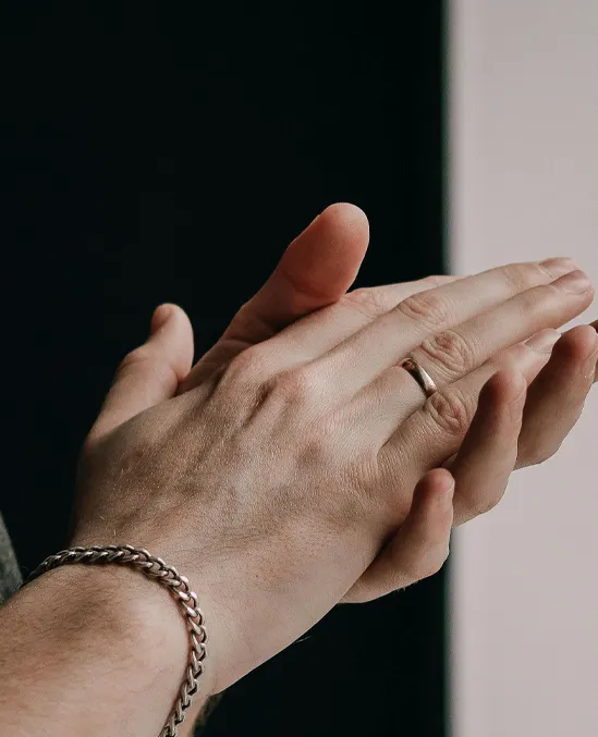 Close-up of hands clapping, showcasing a silver ring and bracelet.