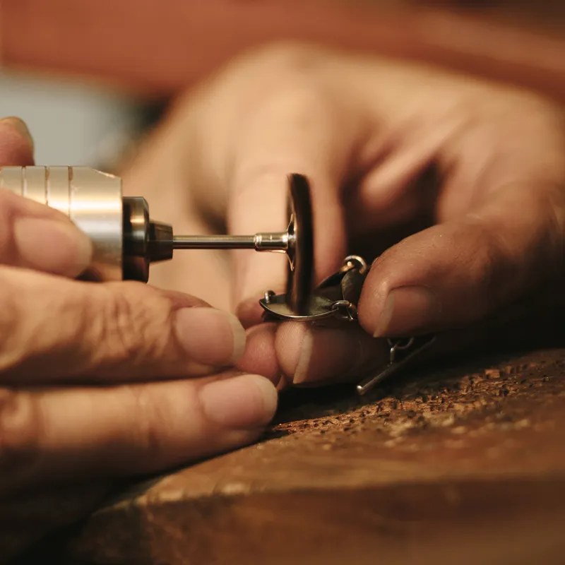 Jeweler using a rotary tool to craft jewelry, showcasing craftsmanship at Tennies Jewelry.