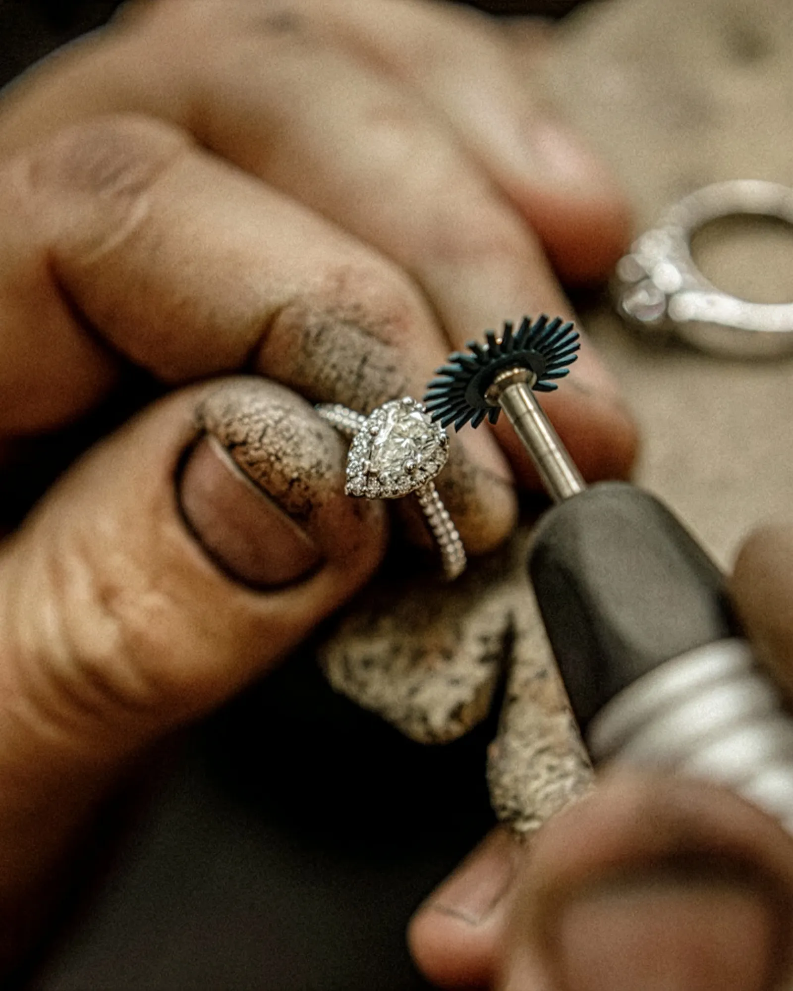 Jeweler carefully setting diamonds in a gold ring, showcasing craftsmanship at Texas Gold Connection in Greenville.