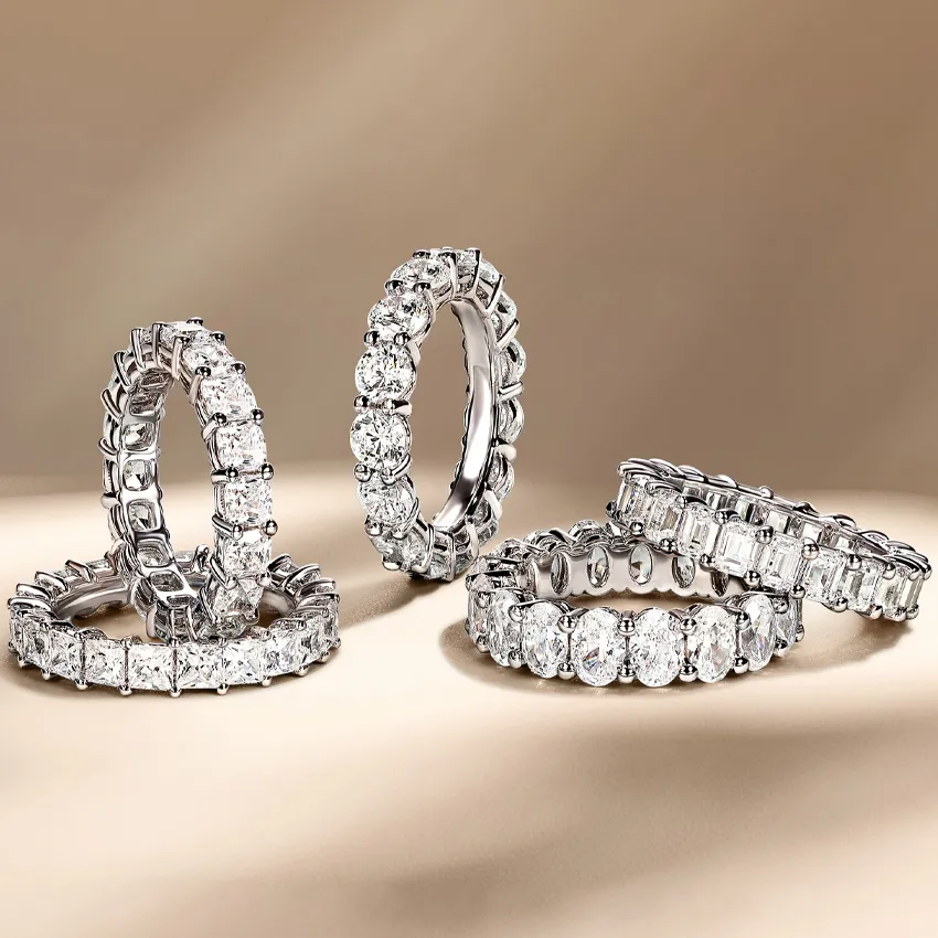 Four elegant diamond wedding bands displayed on a soft background.
