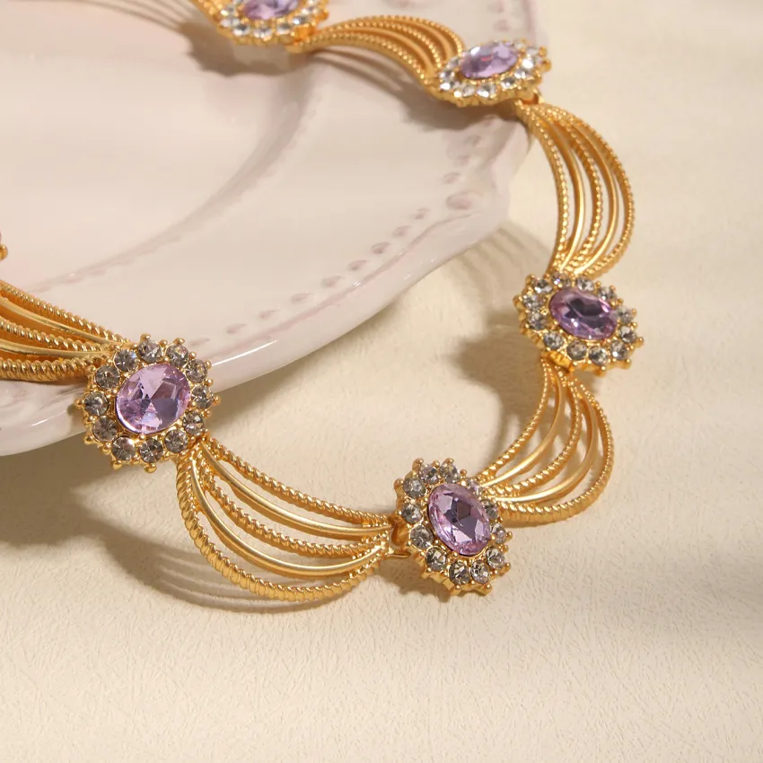 Elegant gold necklace with purple gemstones and intricate design, perfect for special occasions.