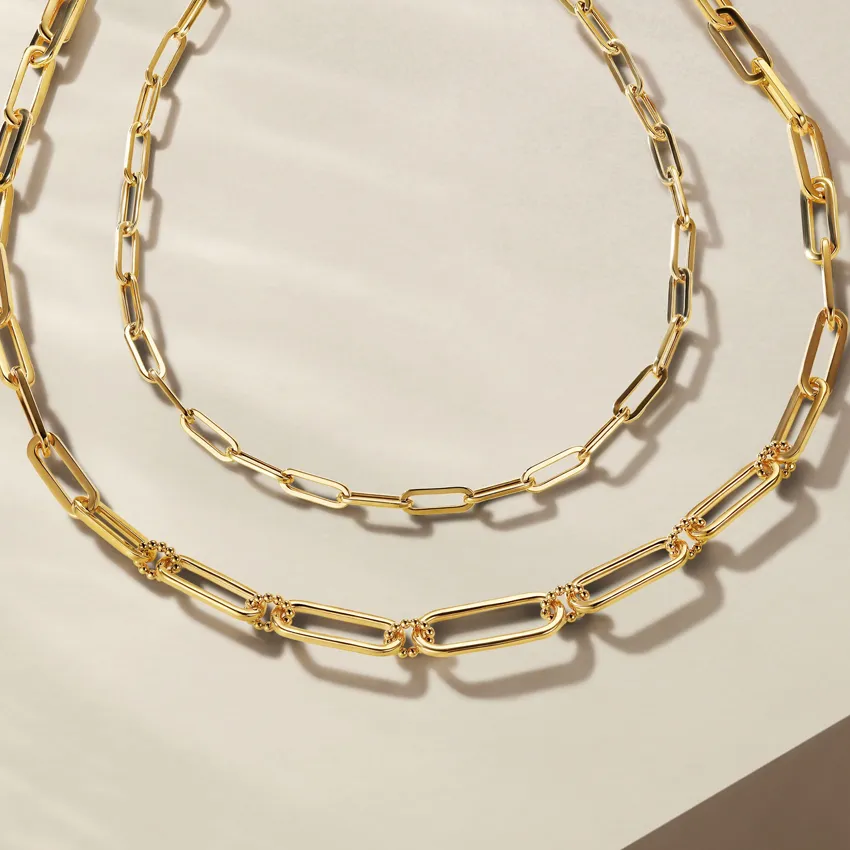Two elegant gold chain necklaces displayed on a light background.