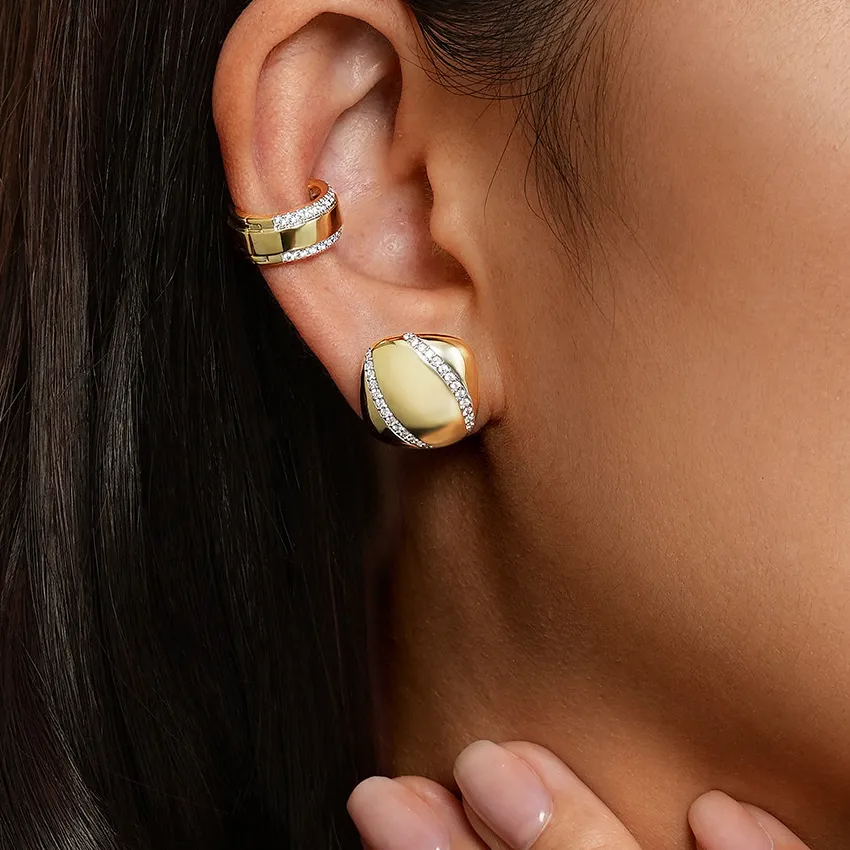 Gold and diamond earrings showcased on a model's ear, highlighting elegance and style.
