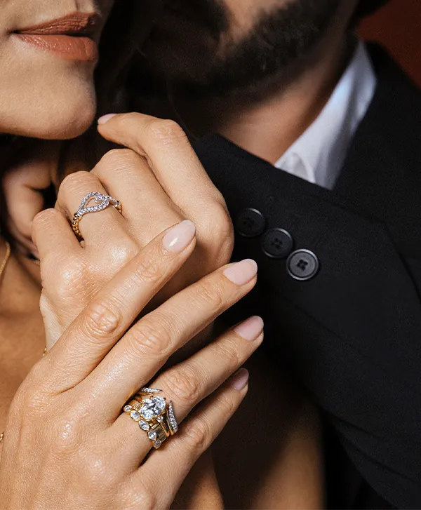 Close-up of hands adorned with elegant rings and bracelets, showcasing fine jewelry from The Diamond Shop, Inc. in Lewiston.