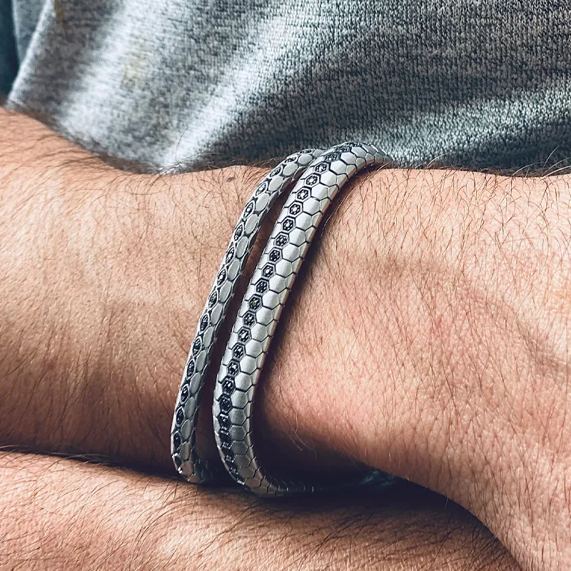 Stylish silver men's bracelet wrapped around a wrist.