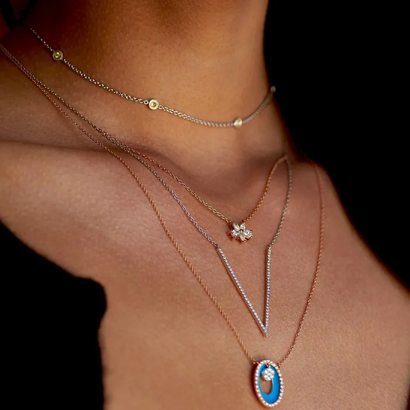 Layered gold and silver necklaces featuring a turquoise pendant and diamond accents.