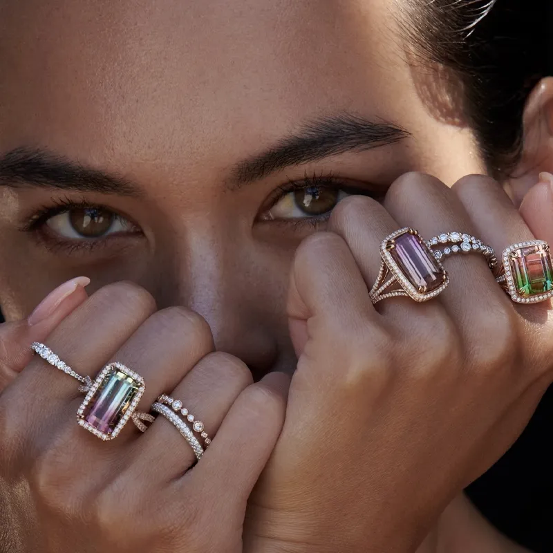 Elegant hands showcasing various gold and diamond rings.