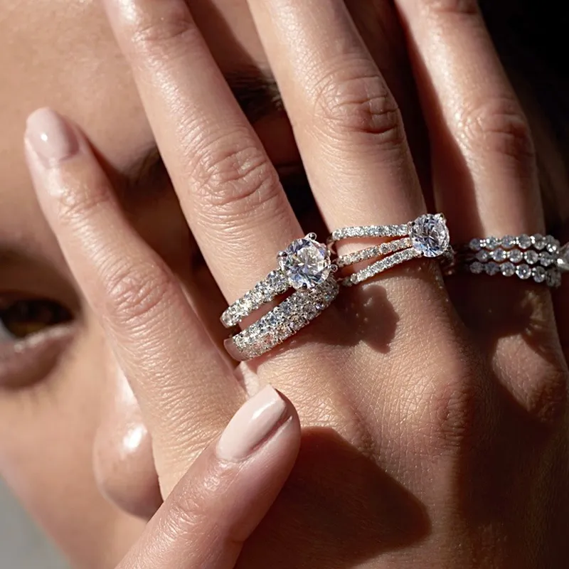 Elegant hand showcasing three diamond rings.