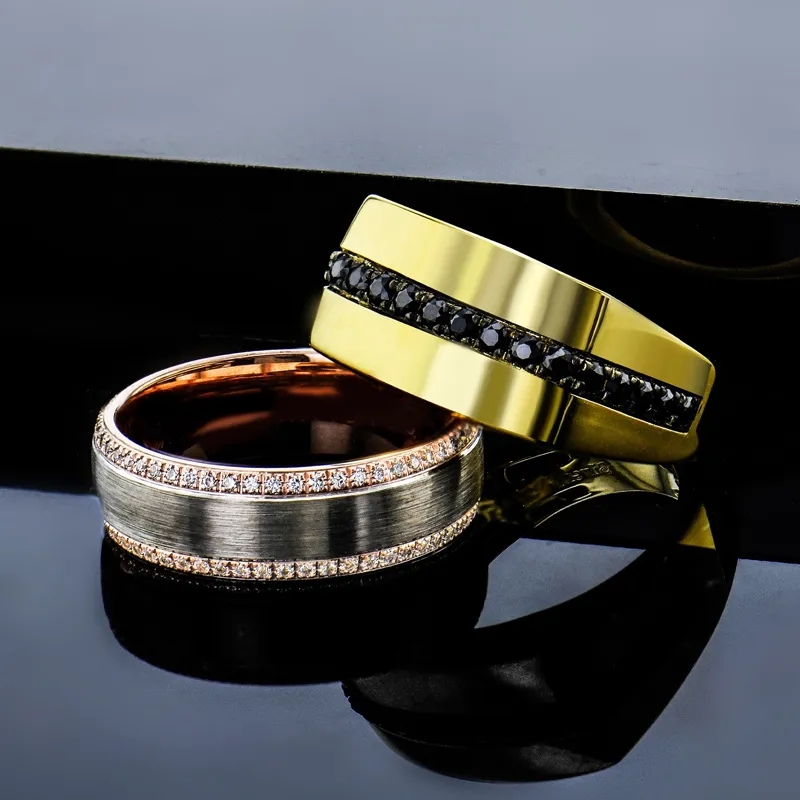 Two stylish men's wedding bands: one gold with black stones, the other silver with diamonds.