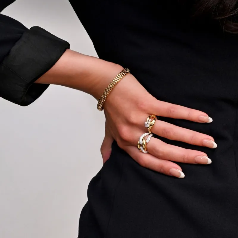 Elegant hand showcasing a gold bracelet and diamond rings.