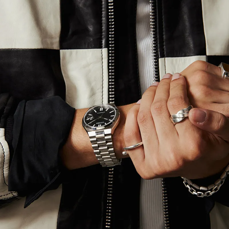 Stylish hand wearing a silver watch and rings, showcasing modern jewelry. 