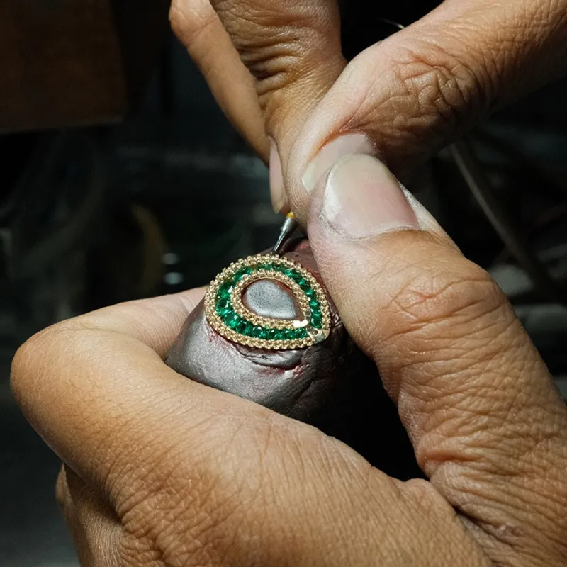Jeweler crafting a custom design ring with green gemstones at The Diamond Shop, Inc. in Lewiston.