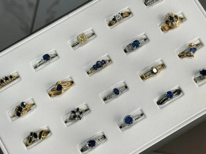 Display of various elegant rings featuring sapphires and diamonds at T.J.'s Fine Jewelry in Carbondale, IL.