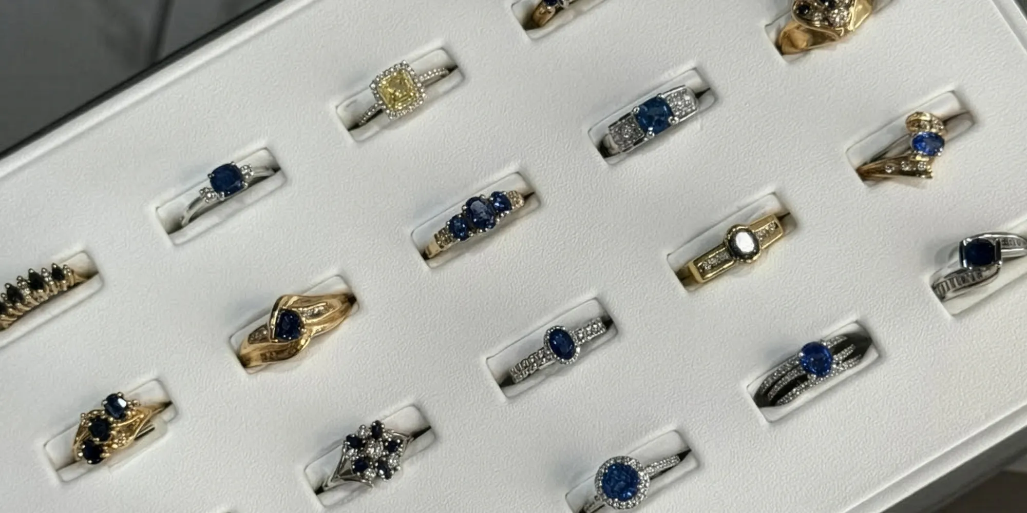 Display of various elegant rings featuring sapphires and diamonds at T.J.'s Fine Jewelry in Carbondale, IL.