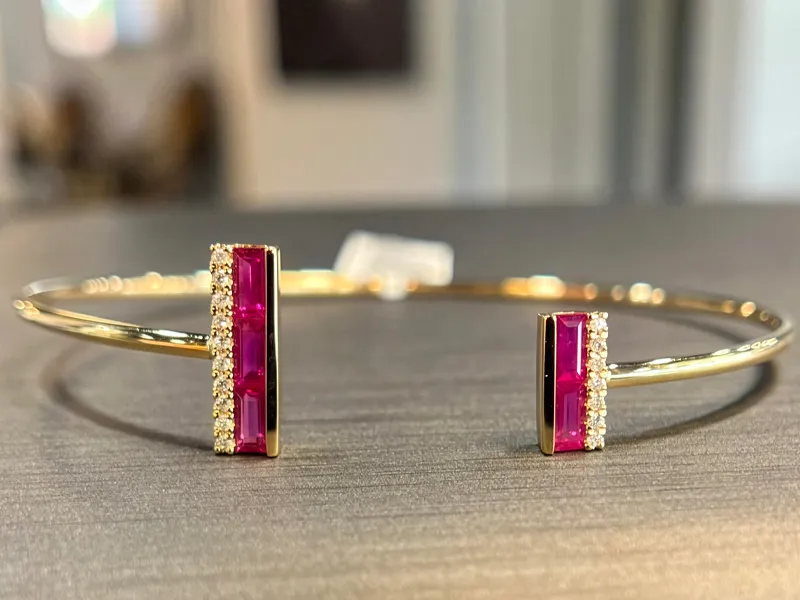 Gold bangle bracelet with pink gemstones and diamond accents, available at T.J.'s Fine Jewelry in Carbondale.