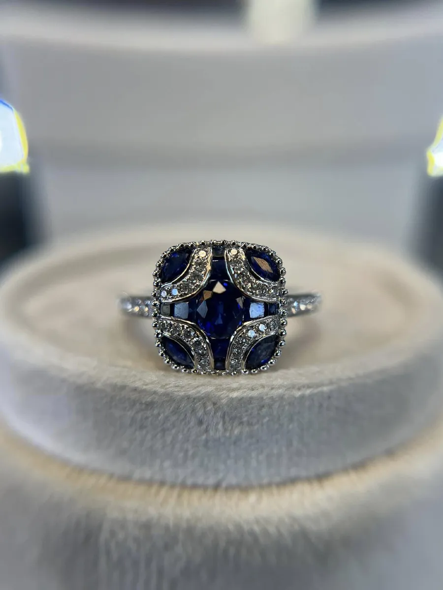 Elegant sapphire and diamond ring displayed on a soft surface at T.J.'s Fine Jewelry in Carbondale.