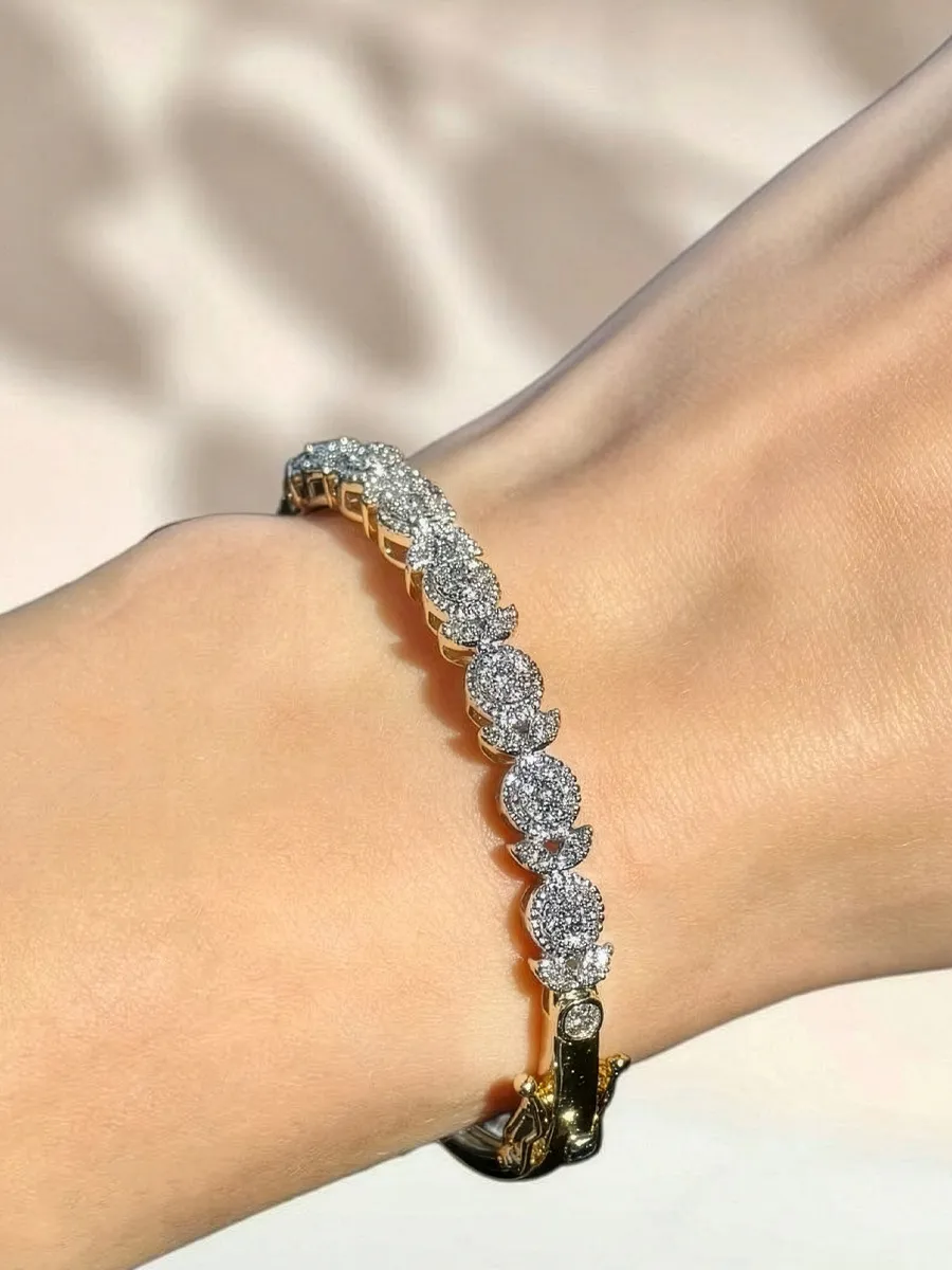 Elegant gold and diamond bracelet on a wrist, showcasing a sparkling design.