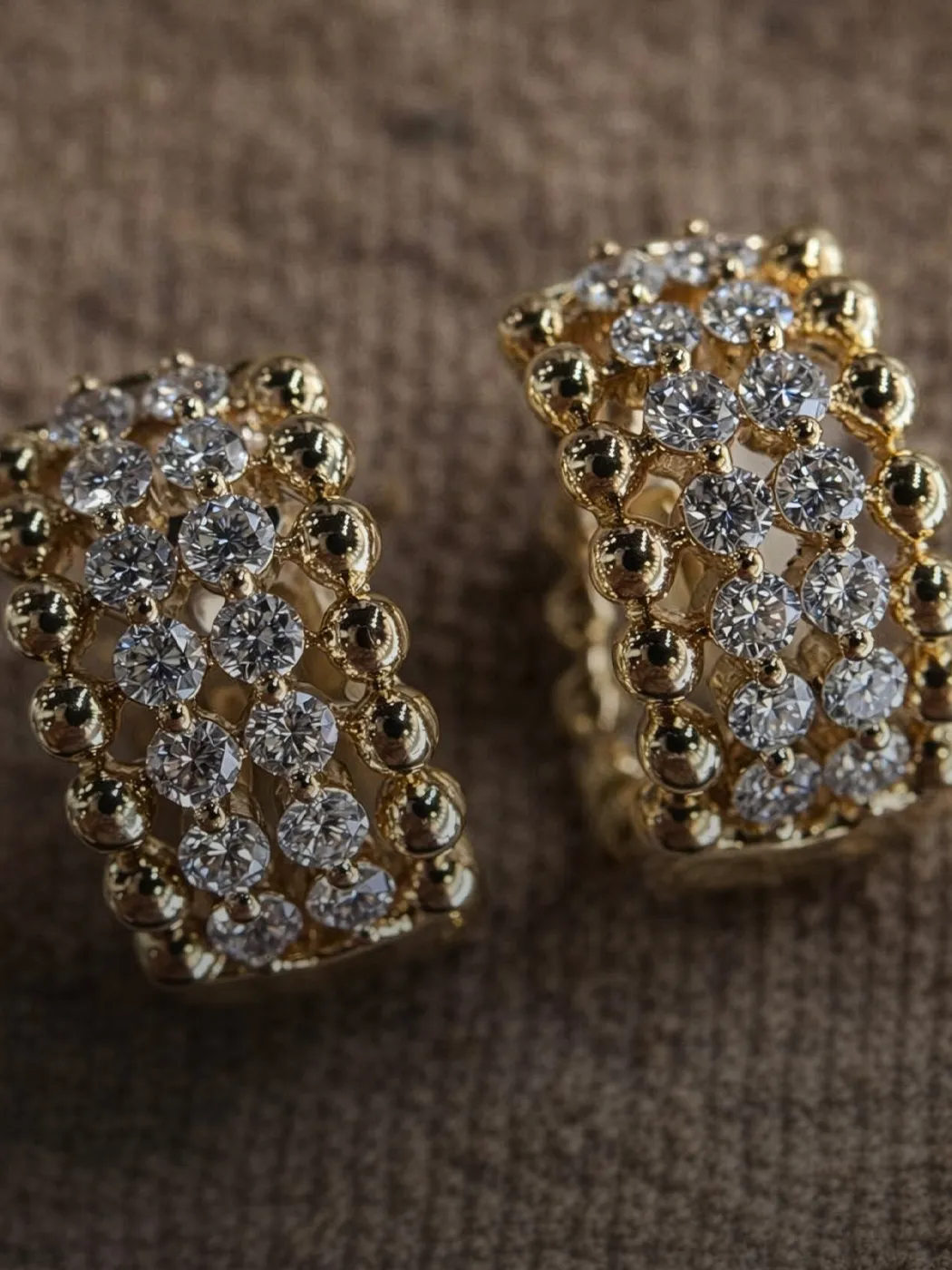 Gold diamond earrings with intricate design, featuring sparkling stones set in a stylish pattern.