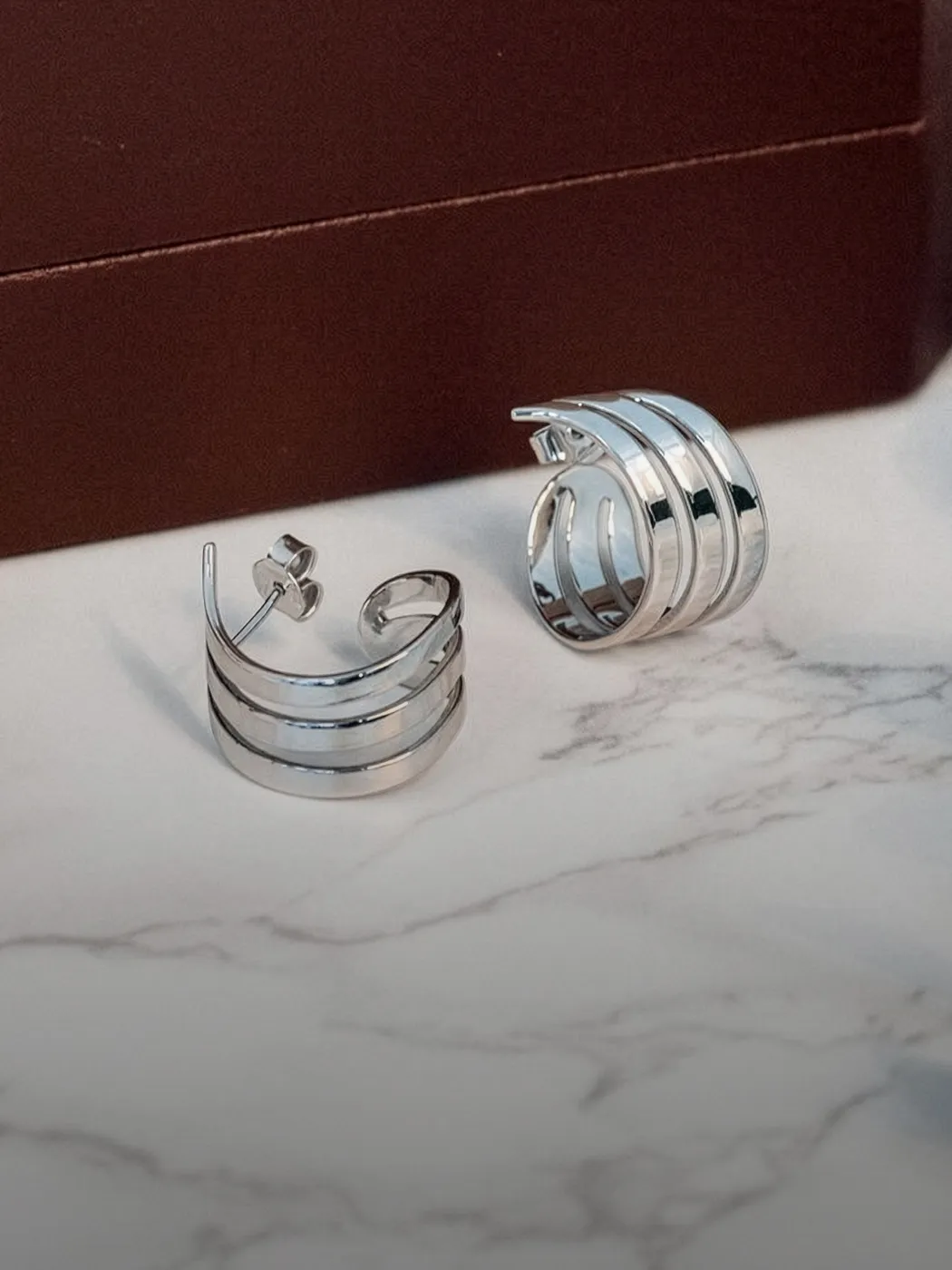 Stylish silver earrings with a wave design, perfect for fashion lovers.