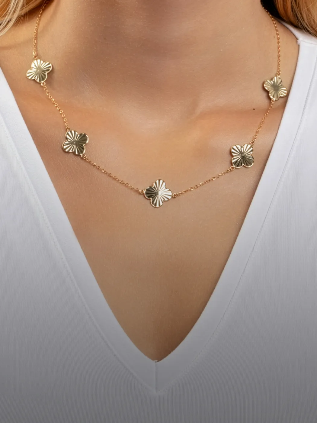 Gold fashion necklace with floral designs worn by a model, showcasing elegance.
