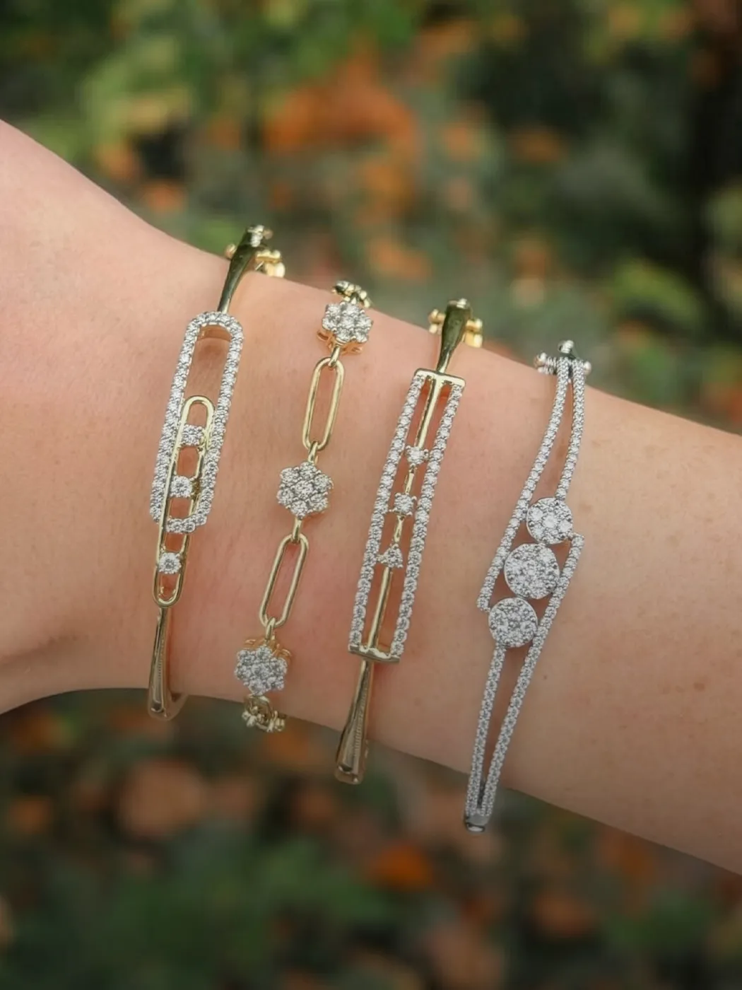 Four elegant bracelets featuring gold and silver designs with sparkling diamonds, perfect for any occasion.
