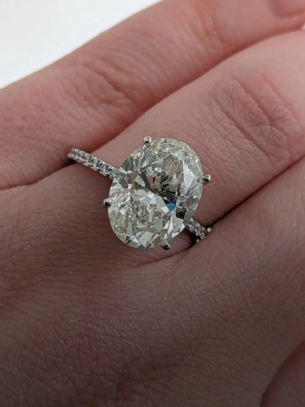 Elegant oval diamond ring with a sparkling band, showcased on a hand.