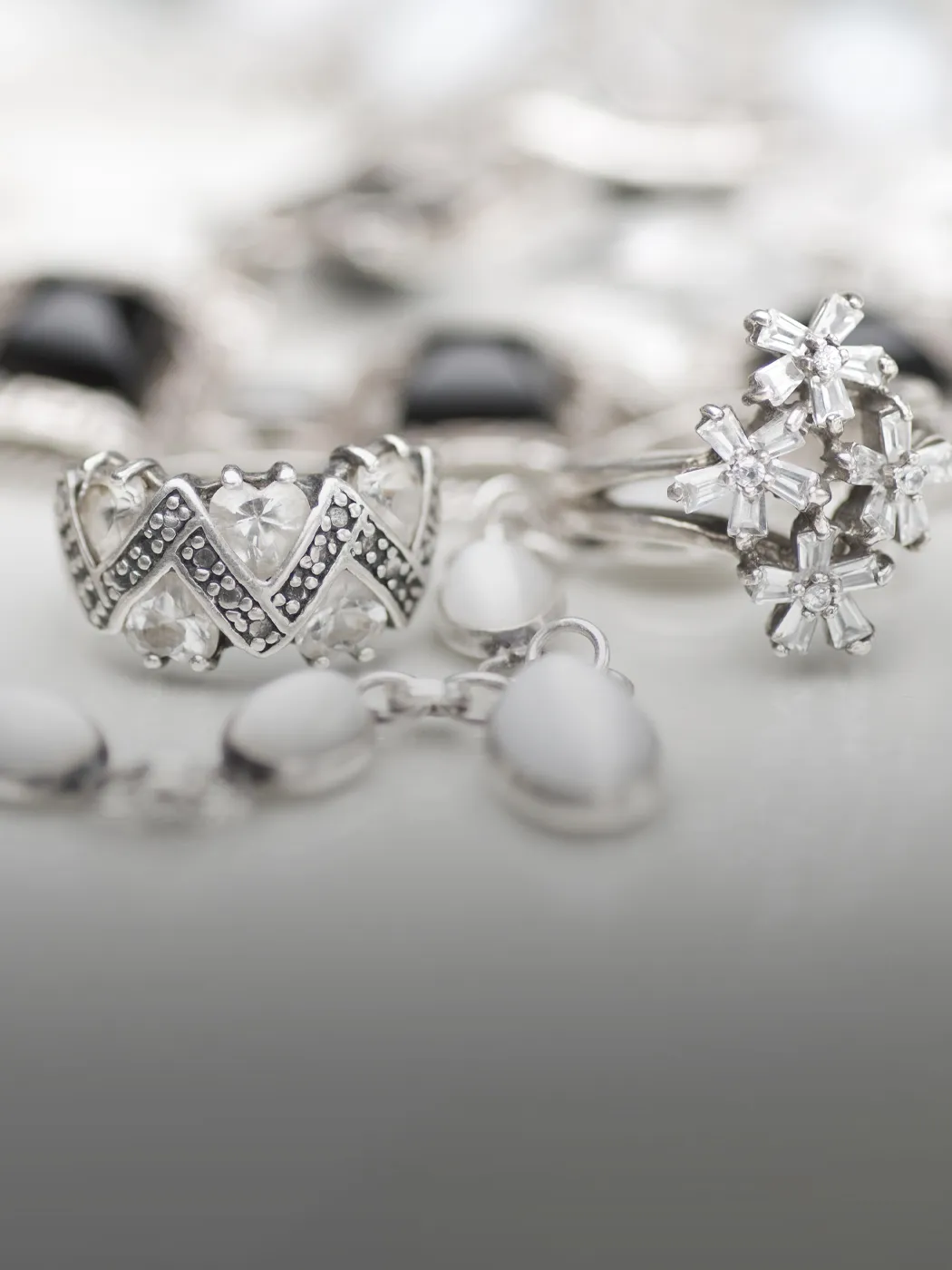 Close-up of silver rings with intricate designs and gemstones.