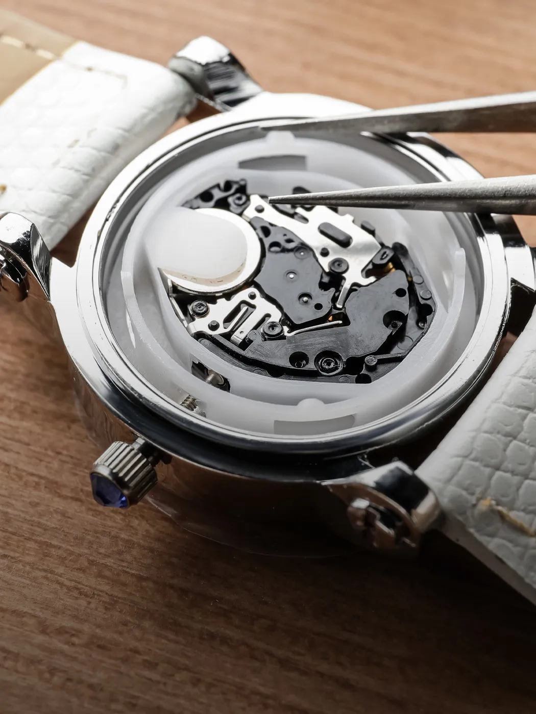 Close-up of a watch movement being repaired, showcasing intricate gears and components.