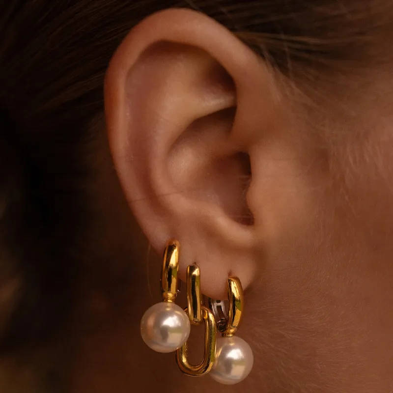 Gold hoop earrings with pearls, showcasing a stylish design.