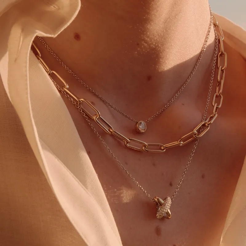 Layered gold and silver necklaces on a model, showcasing elegant jewelry