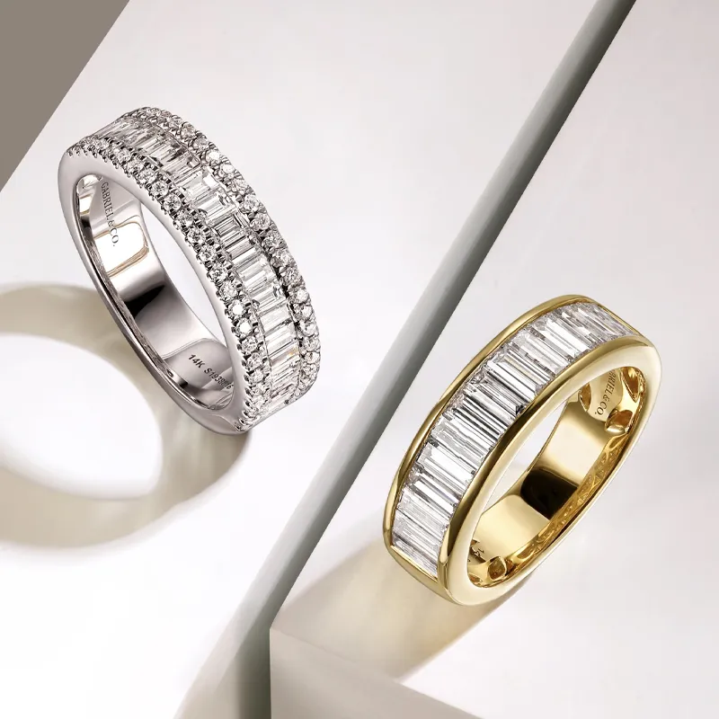 Two elegant wedding bands, one in white gold with diamonds and the other in yellow gold, displayed on a light background.