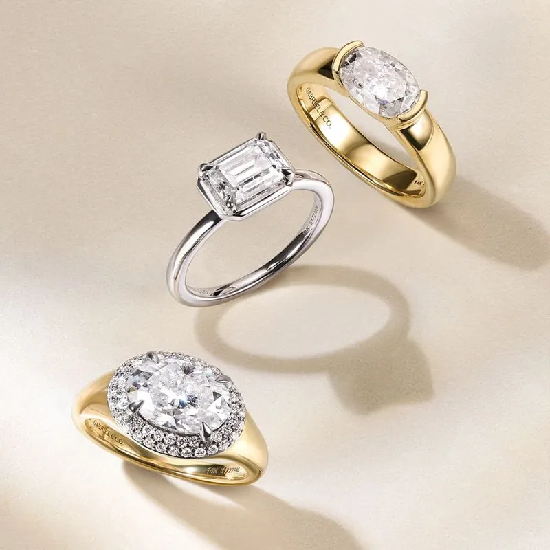 Three elegant engagement rings featuring diamonds in gold and silver settings, showcasing various styles and designs.