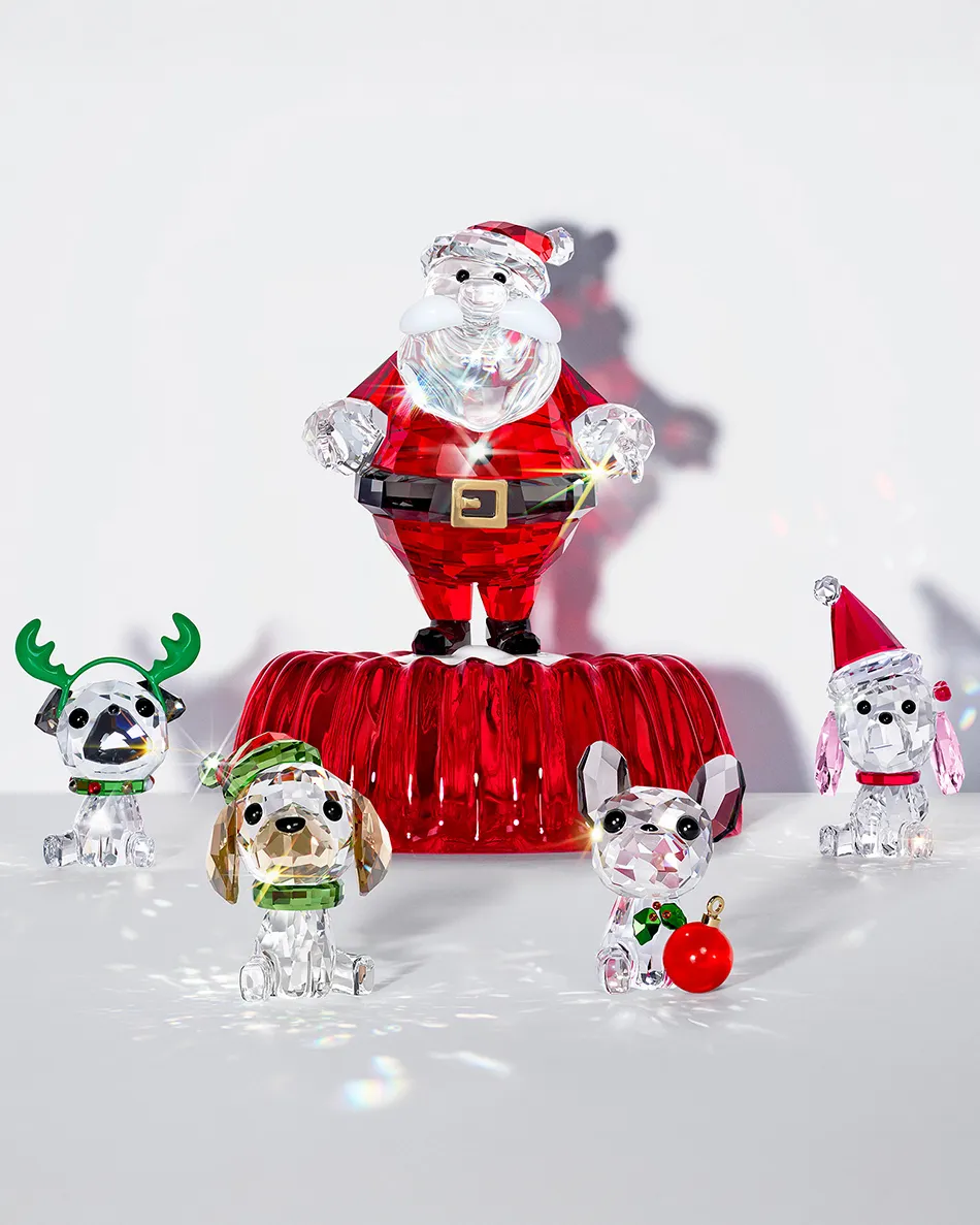Colorful crystal figurines of Santa and four dogs in festive attire, showcasing holiday cheer.
