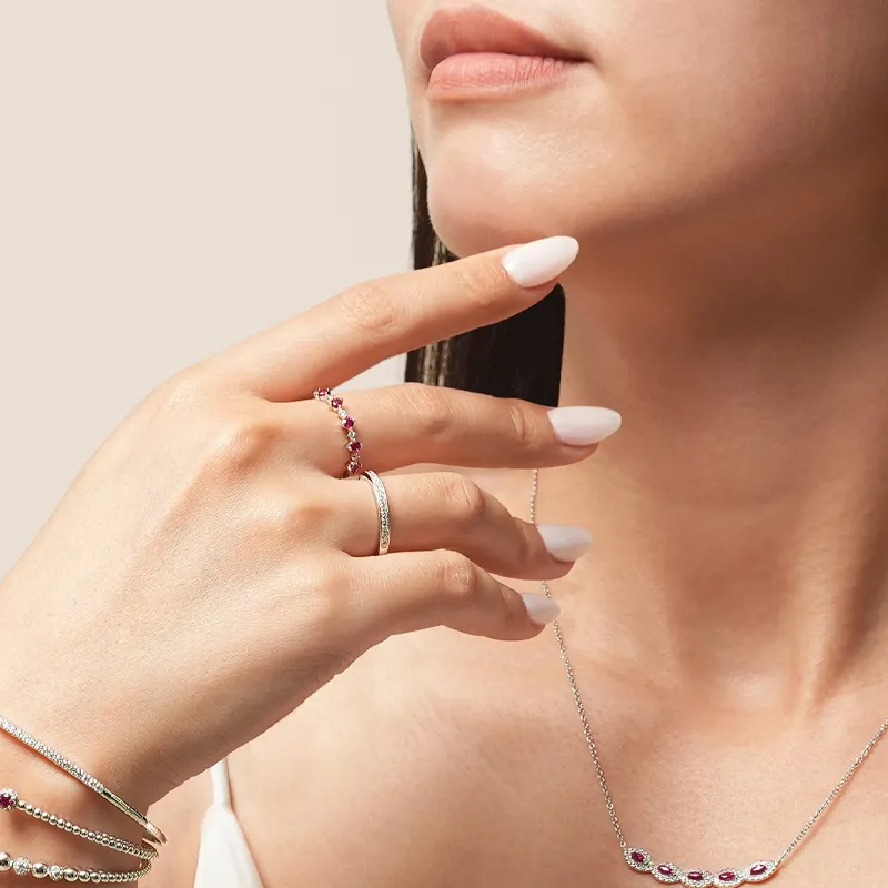 A woman showcasing elegant rings and a necklace, highlighting fine jewelry.
