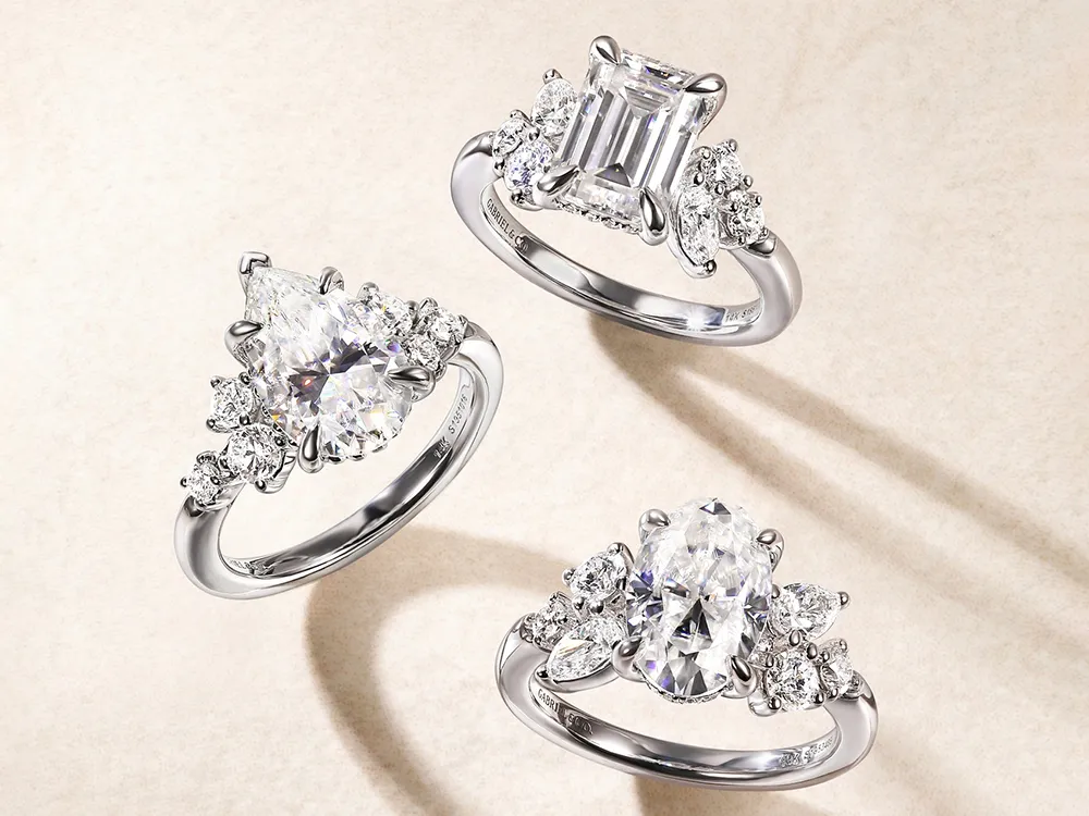Three elegant diamond rings with various cuts and settings on a light background.