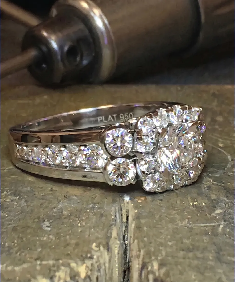 Diamond ring with multiple stones on a wooden surface, showcasing intricate design and sparkle.