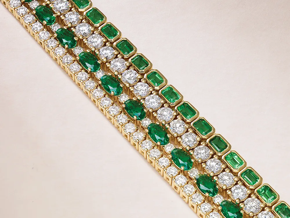Gold bracelet with alternating rows of emeralds and diamonds.