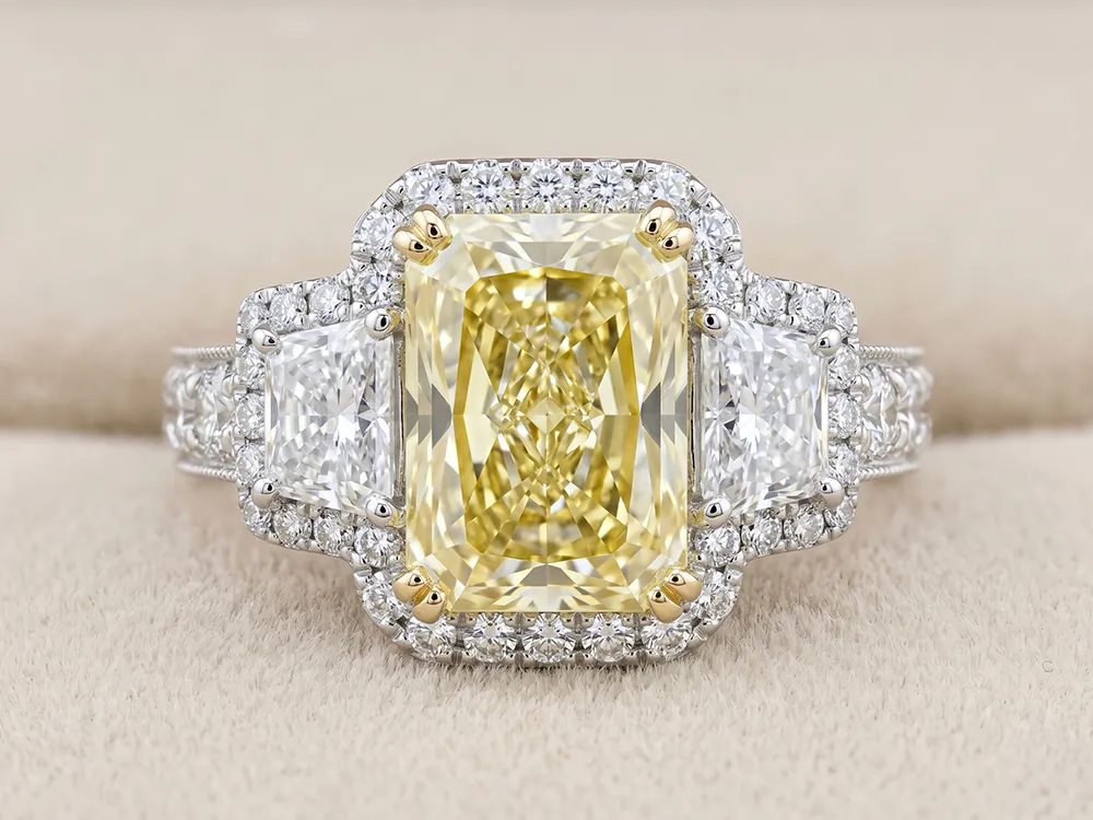 Elegant ring with a large yellow diamond center, flanked by white diamonds, set in a detailed band.