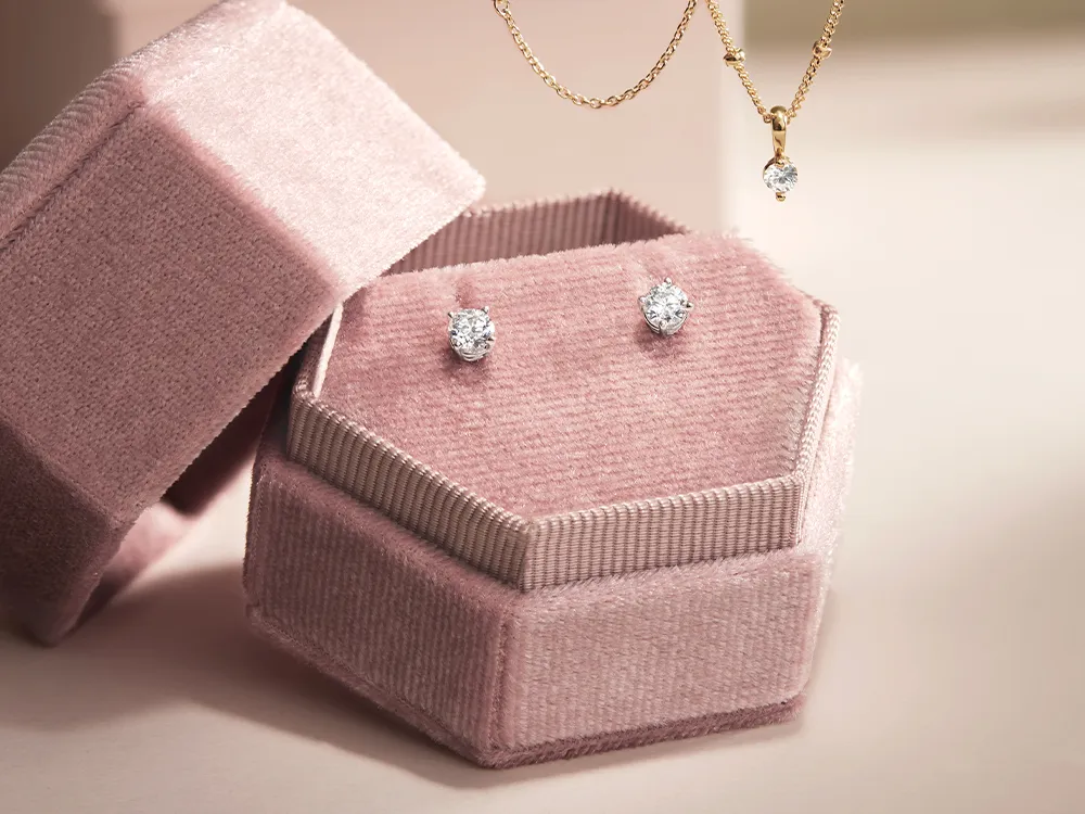 Diamond studs and necklace in a pink velvet box.