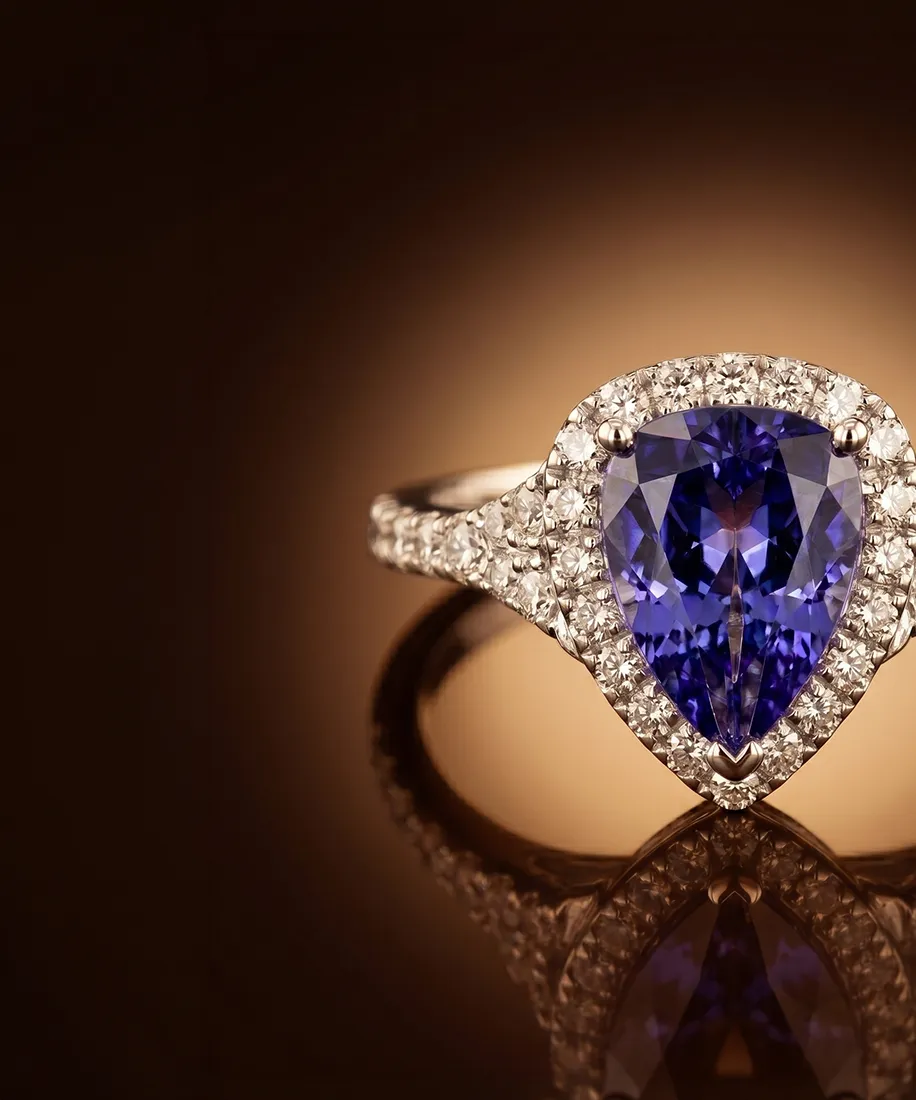 A diamond ring with a blue gemstone centerpiece on a reflective surface.