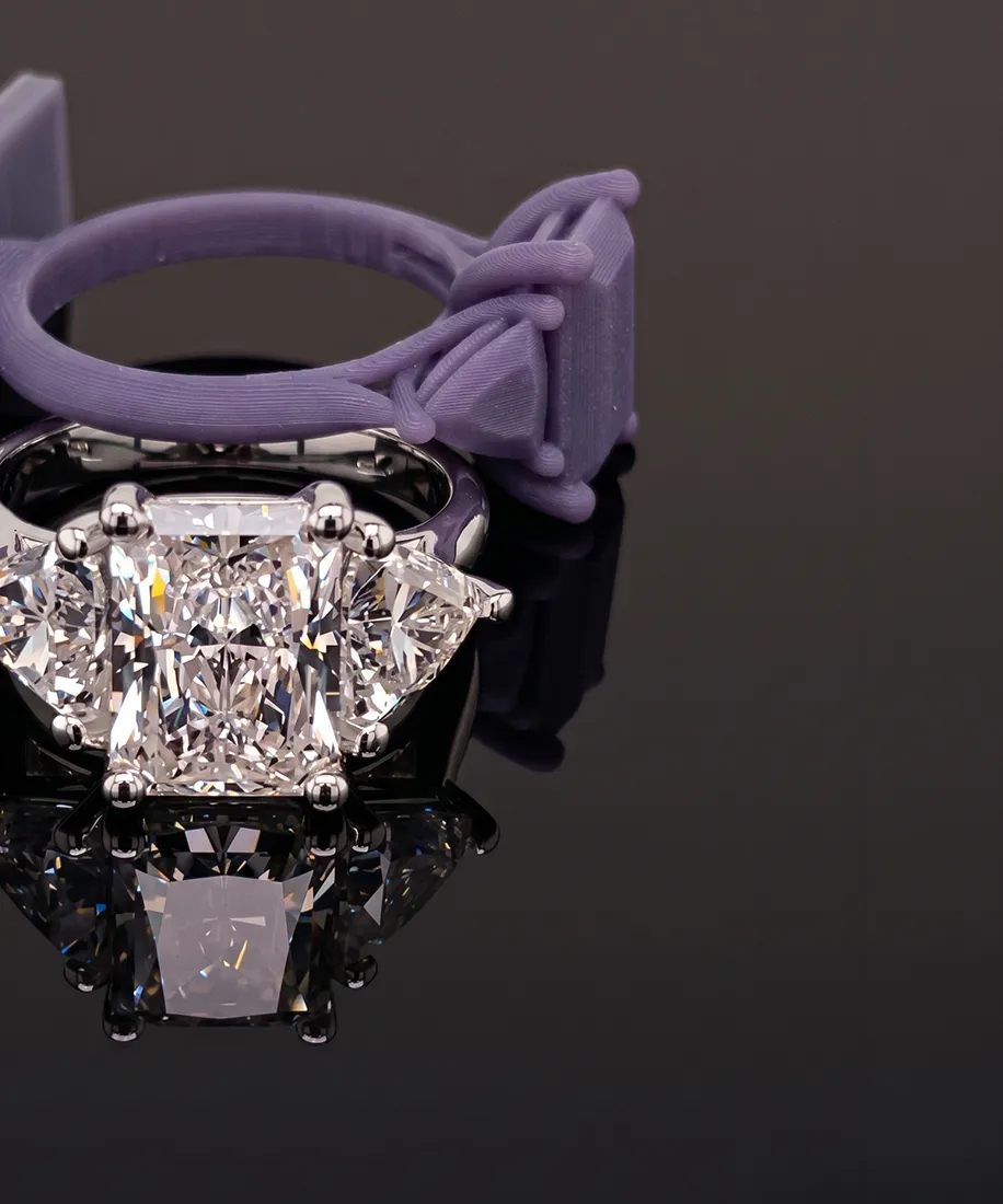 Elegant diamond ring with a large central stone and intricate detailing on a reflective surface.