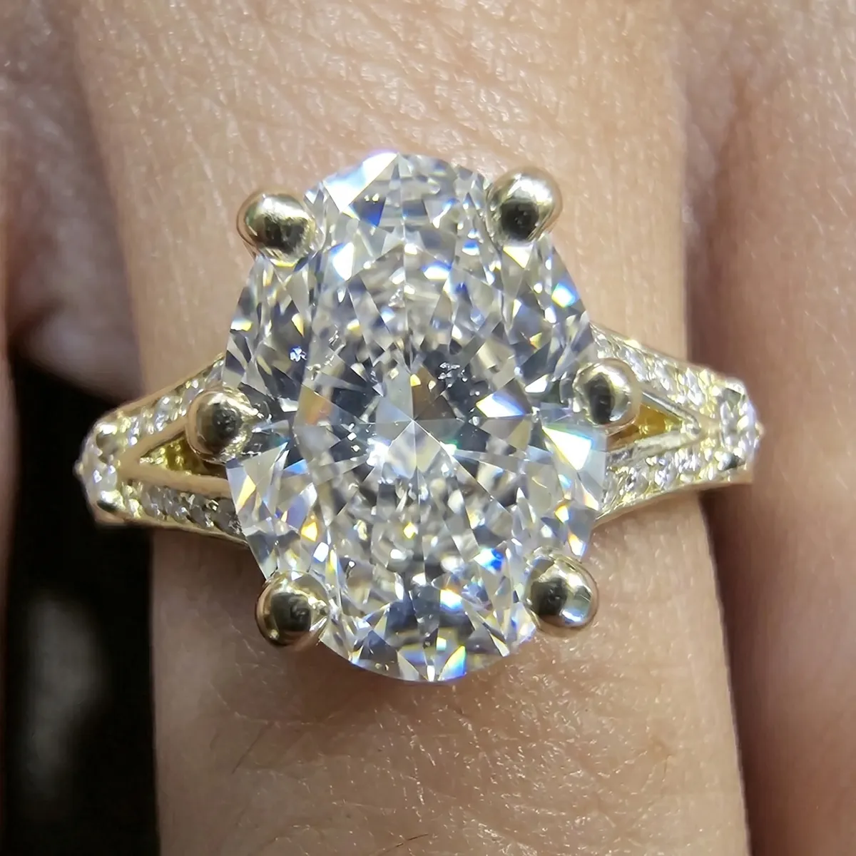 A large oval diamond ring with a gold band and smaller diamonds on the sides.