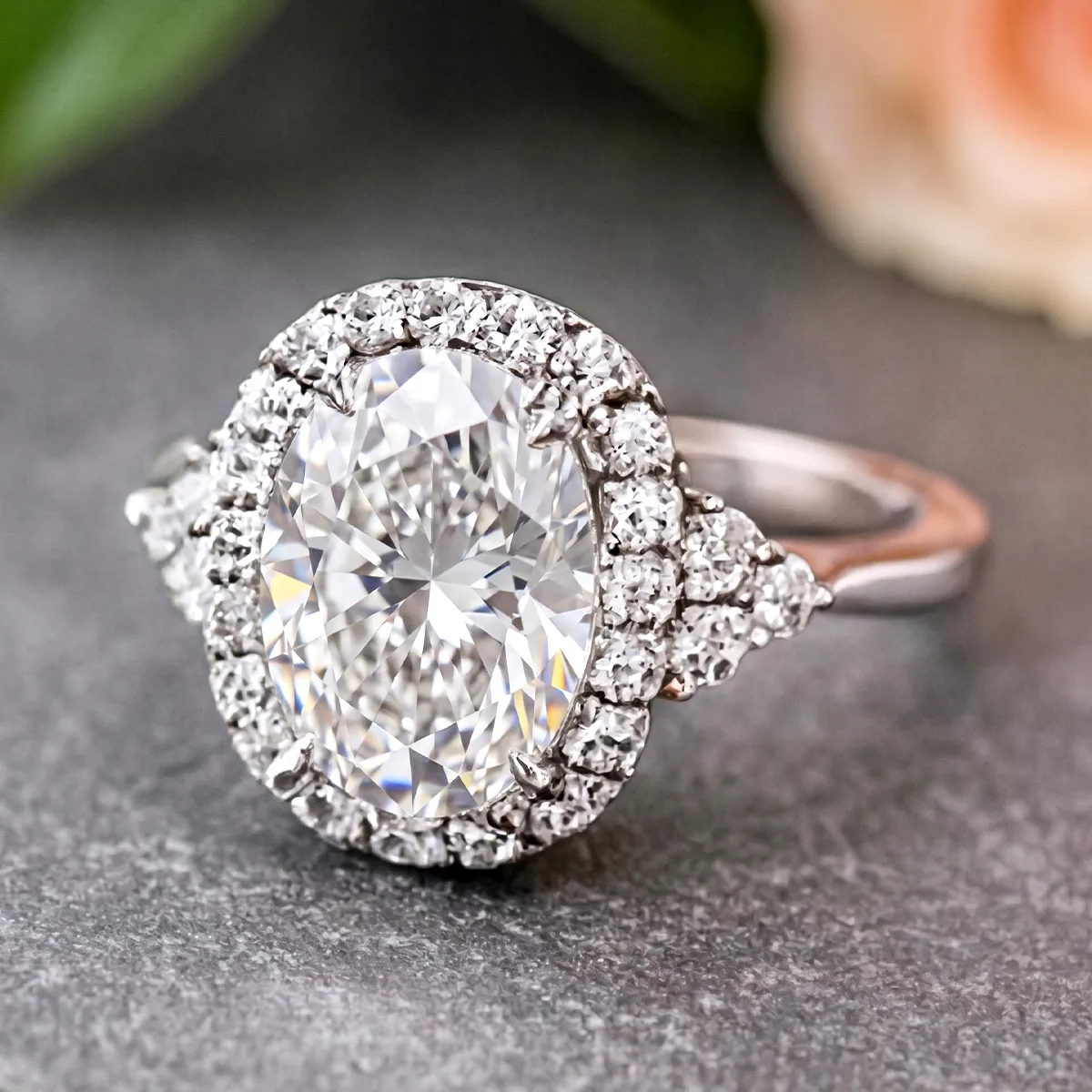 Diamond engagement ring set with round-cut stones on a textured surface.
