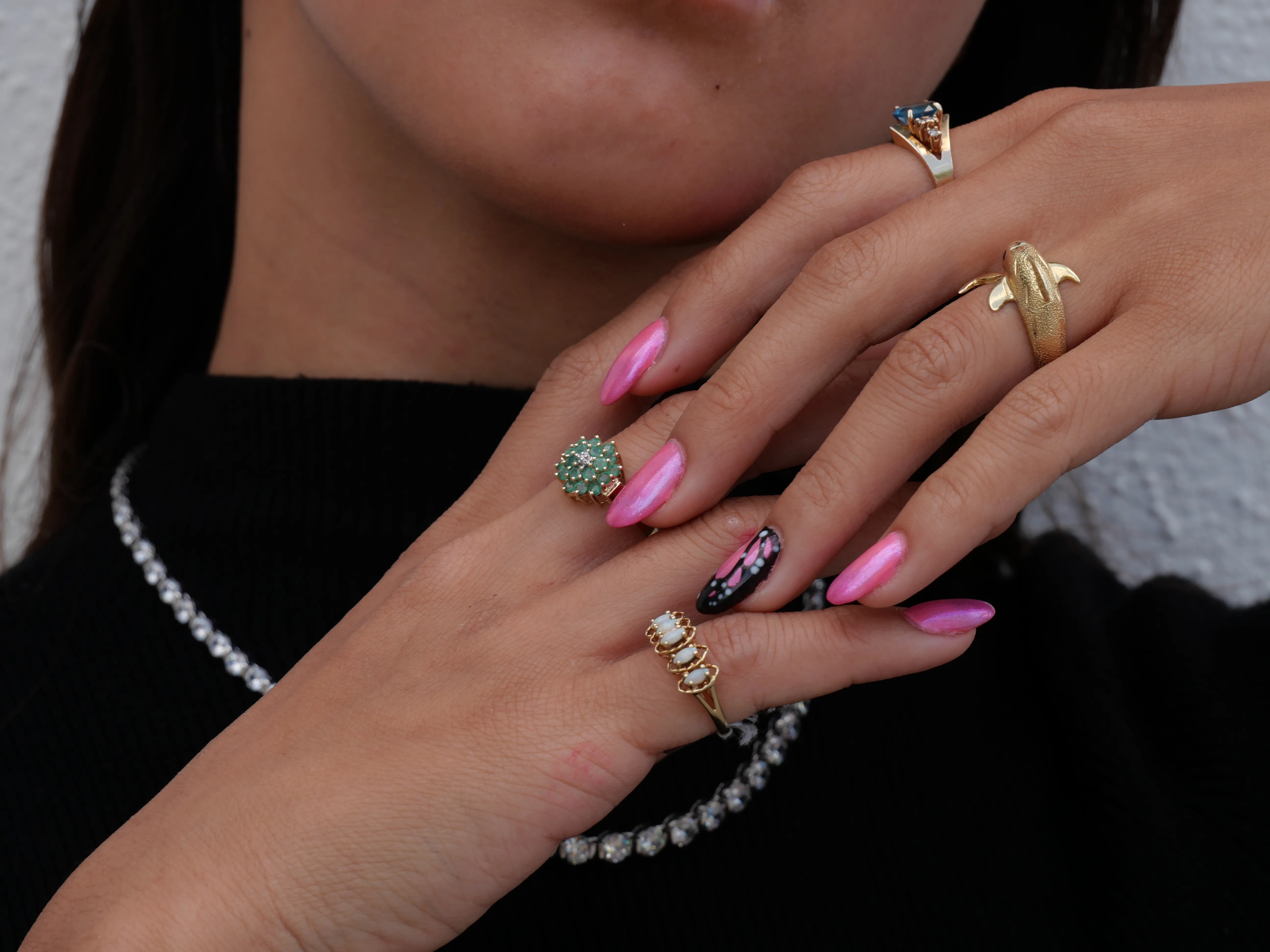 Elegant rings displayed on a hand with pink nails. Click to explore more at Masterpiece Jewelers in Daytona Beach.