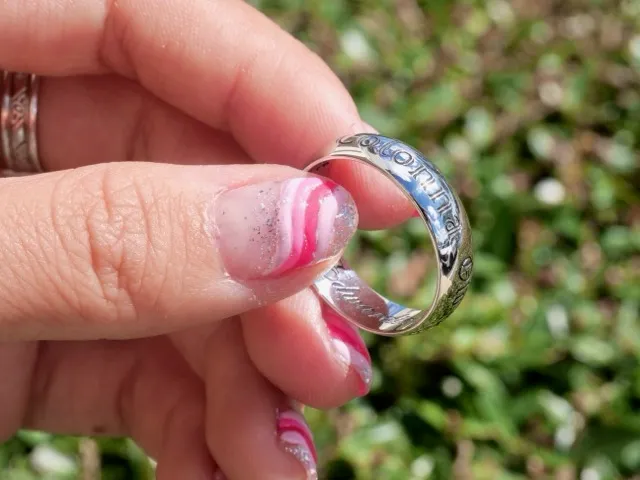 Close-up of a silver ring with engravings. Click to explore jewelry engraving options at Masterpiece Jewelers.