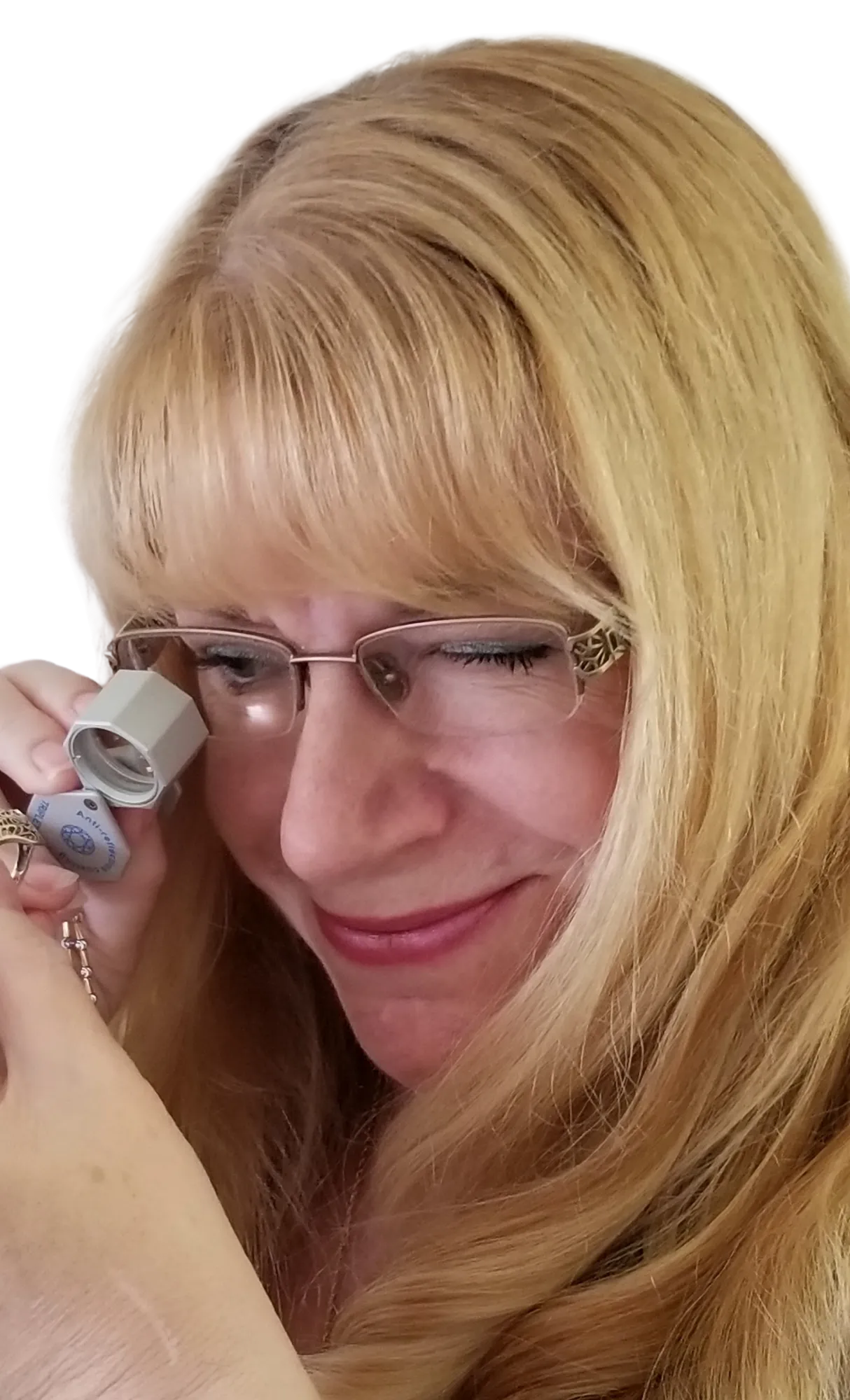 A close-up of a silver ring with a blue gemstone, viewed through a magnifying glass. 