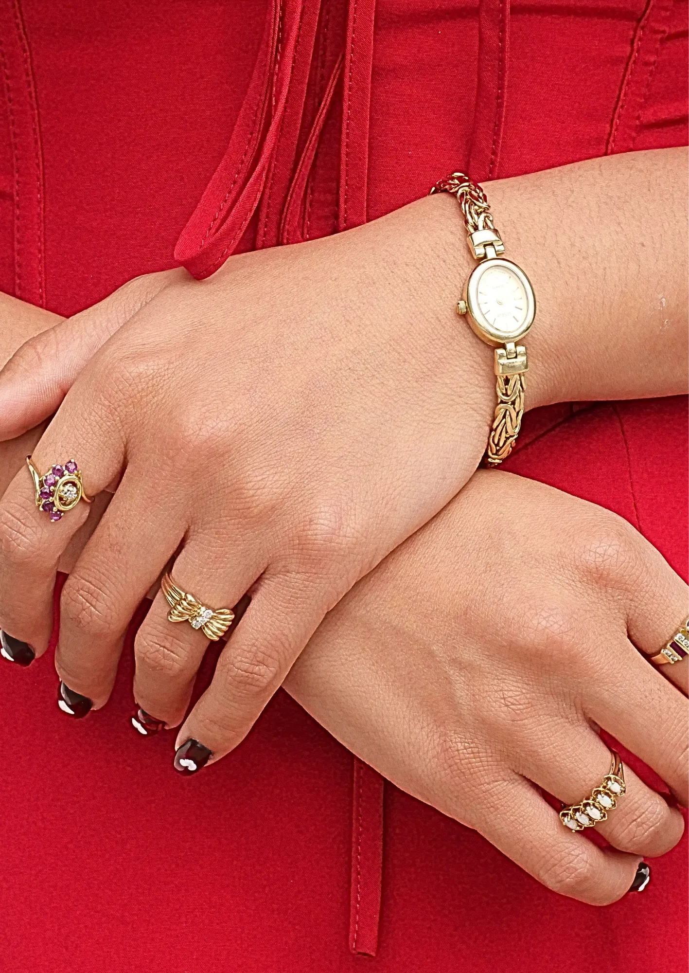 A hand adorned with multiple gold and diamond rings, showcasing elegant jewelry from Masterpiece Jewelers in Daytona Beach.