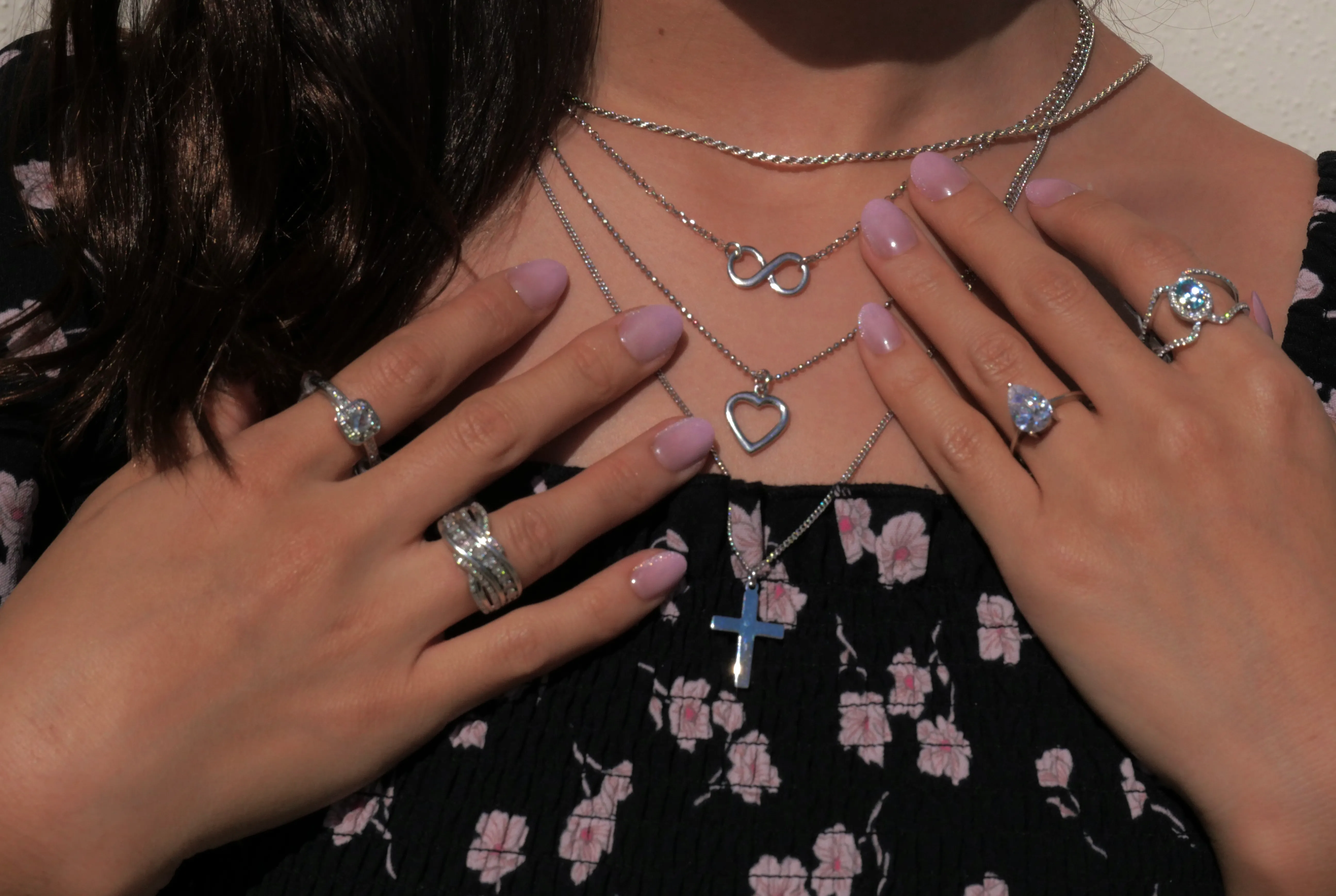 Close-up of a person wearing two elegant sterling rings. Shop fine jewelry at Masterpiece Jewelers in Daytona Beach.
