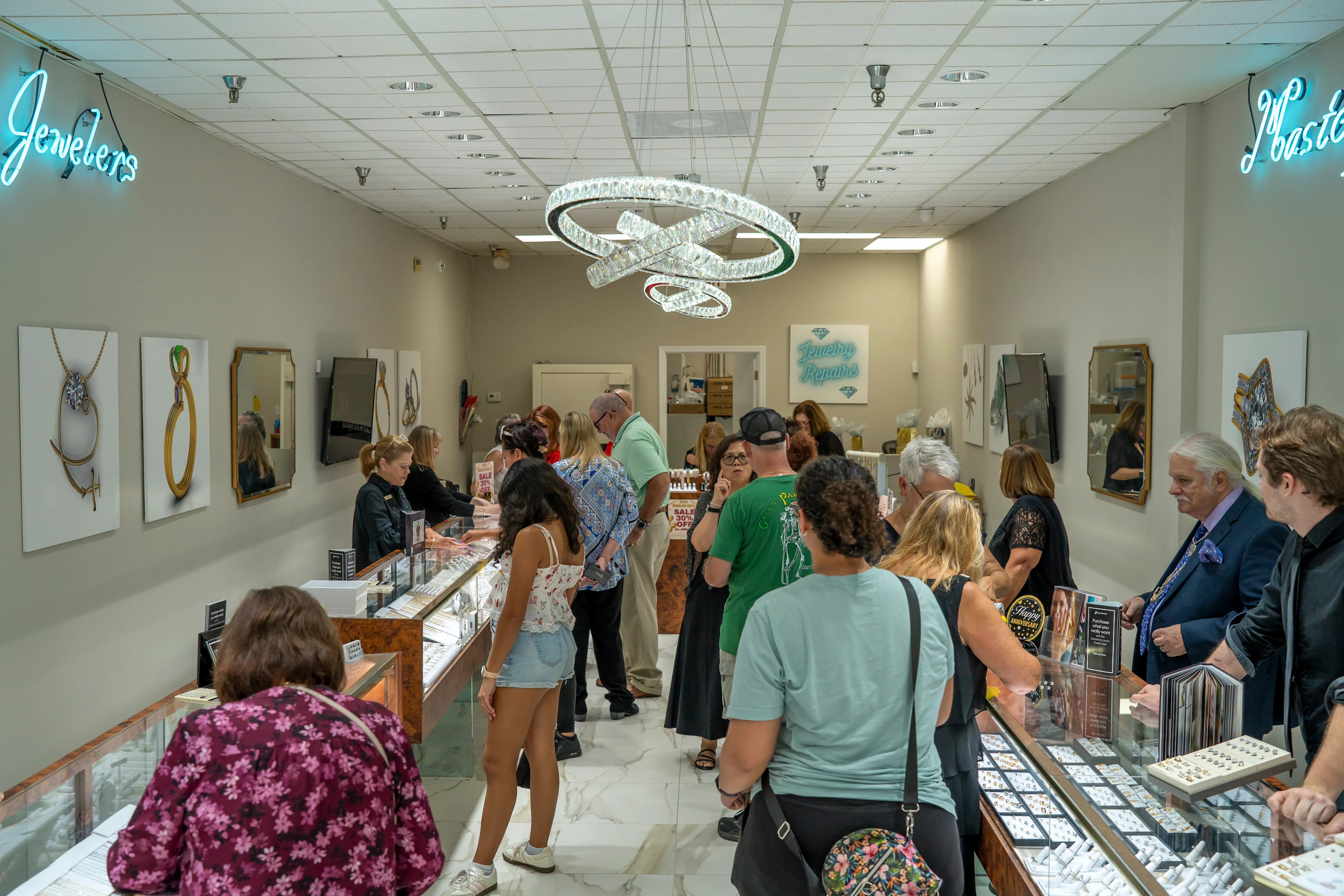 Inside of the Masterpiece Jewelers showroom, full of people that Tracy and Stacy are helping.