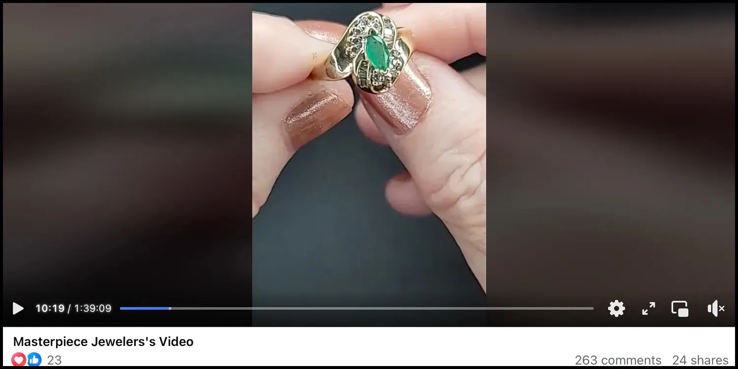 Hand holding a gold ring with a green stone, featured in a video by Masterpiece Jewelers.